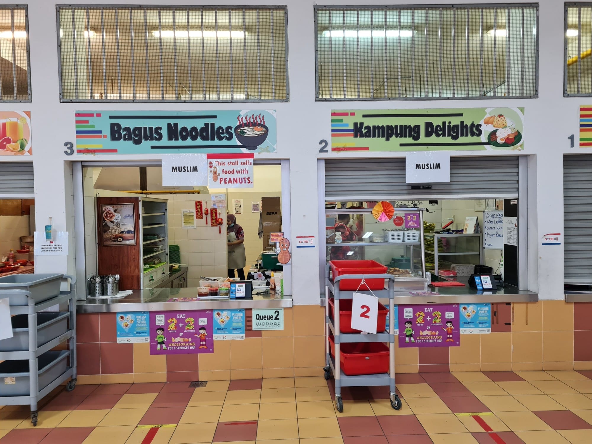 Two Muslim halal food stalls, Bagus Noodles and Kampung Delights, in a Singapore hawker centre.